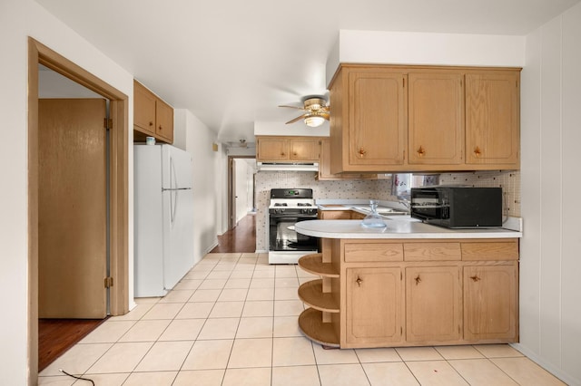 31 W 126th Pl, Chicago, IL 60628 - kitchen featuring gas range oven, black microwave, a peninsula, freestanding refrigerator, and under cabinet range hood