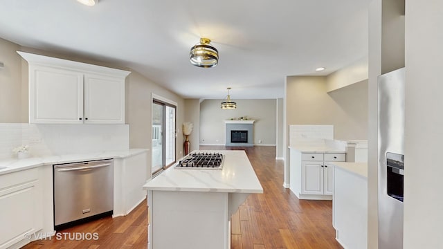 kitchen featuring light wood-style flooring, decorative backsplash, white cabinetry, and stainless steel appliances