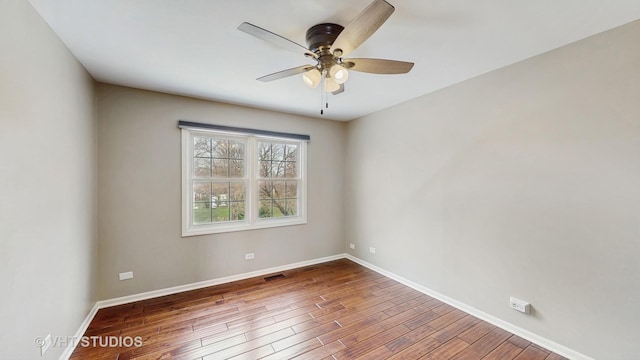 empty room featuring visible vents, baseboards, a ceiling fan, and wood finished floors