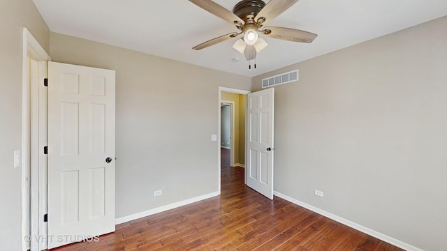 unfurnished bedroom featuring visible vents, baseboards, a ceiling fan, and wood finished floors