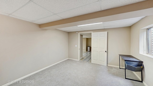 interior space featuring carpet flooring, a paneled ceiling, and baseboards