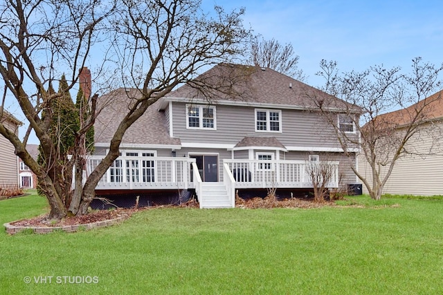 rear view of property with roof with shingles, a yard, and a deck