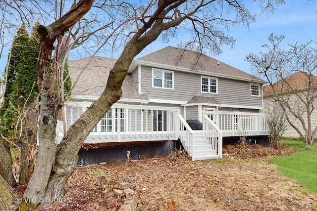 back of house featuring a deck and roof with shingles