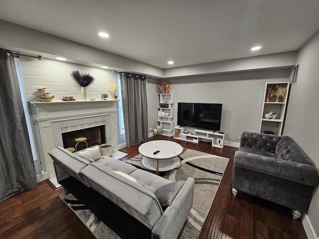 living area featuring baseboards, recessed lighting, wood finished floors, and a fireplace