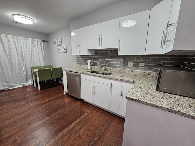 kitchen with stainless steel dishwasher, light stone countertops, dark wood-type flooring, a sink, and backsplash
