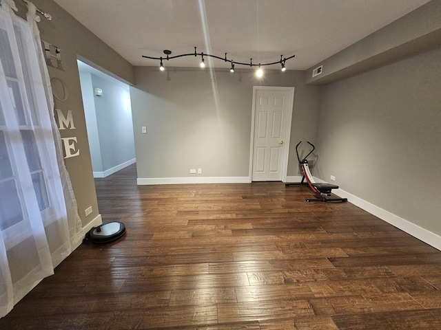empty room with baseboards, wood-type flooring, and visible vents