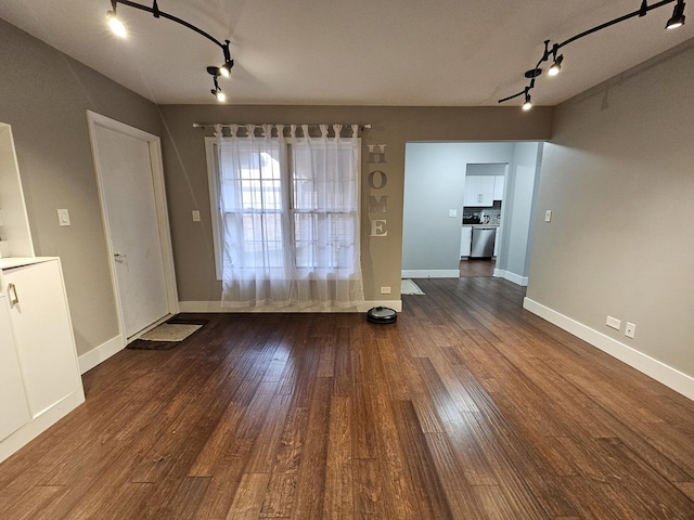 unfurnished dining area with baseboards and dark wood finished floors