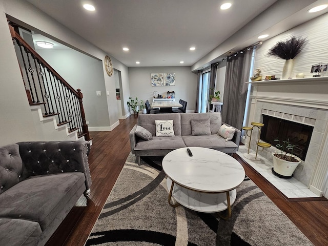 living area featuring baseboards, recessed lighting, stairway, wood finished floors, and a tile fireplace