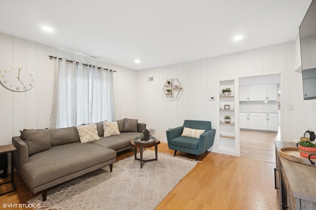 living room with recessed lighting, light wood finished floors, and visible vents
