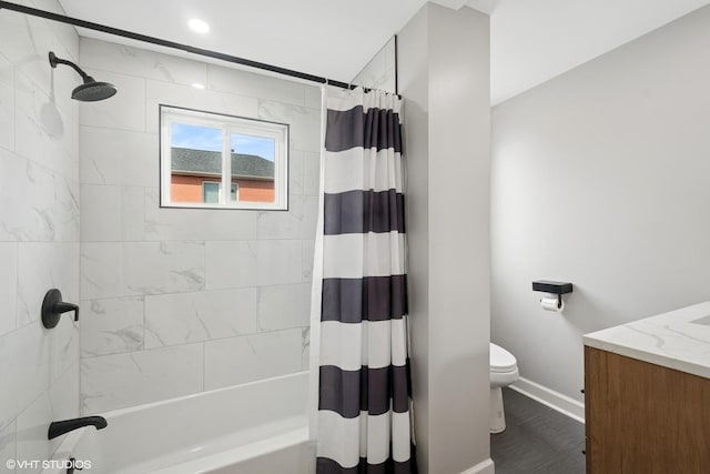 bathroom with shower / bath combo, toilet, vanity, and baseboards