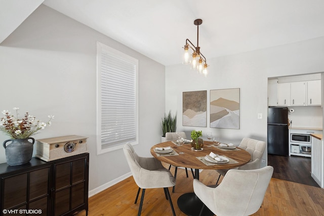 dining room featuring light wood-style flooring and baseboards