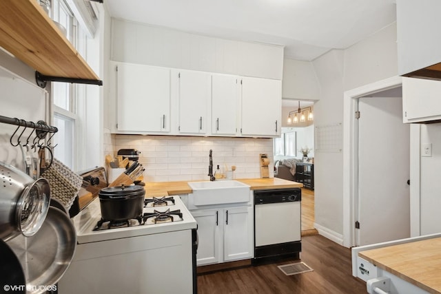 kitchen featuring visible vents, white cabinets, a sink, white appliances, and butcher block counters