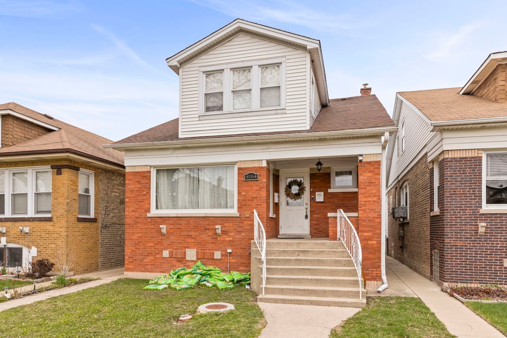 4164 W Wellington Ave, Chicago, IL 60641 - bungalow-style home with a porch, a shingled roof, a front yard, and brick siding