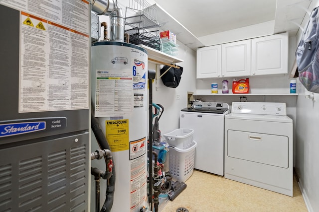 laundry area with water heater, heating unit, cabinet space, light floors, and washing machine and clothes dryer