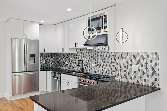 kitchen featuring dark stone countertops, appliances with stainless steel finishes, decorative backsplash, and a sink