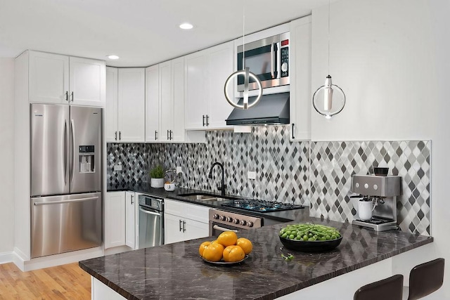 kitchen featuring white cabinets, light wood-type flooring, a sink, and appliances with stainless steel finishes