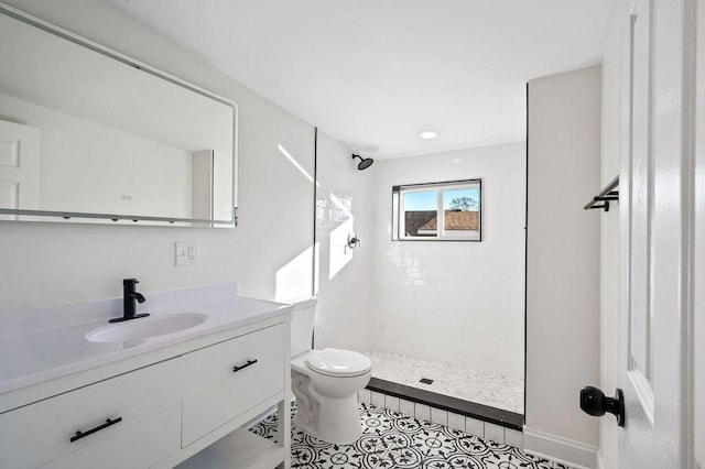 full bathroom with toilet, tile patterned flooring, a tile shower, and vanity