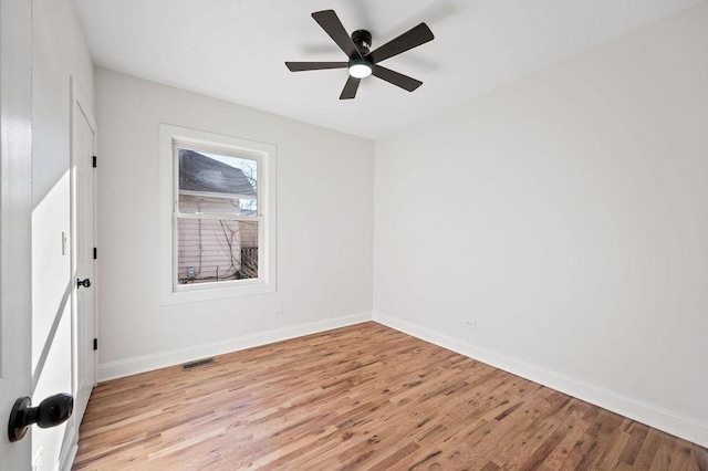 empty room with visible vents, light wood-type flooring, baseboards, and ceiling fan