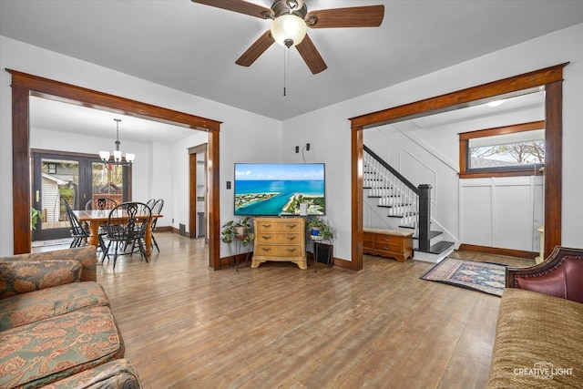 627 S Main St, Montgomery, IL 60538 - living room featuring wood finished floors, baseboards, stairway, and ceiling fan with notable chandelier