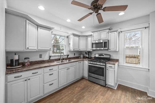 627 S Main St, Montgomery, IL 60538 - kitchen with a sink, dark wood finished floors, dark countertops, baseboards, and appliances with stainless steel finishes