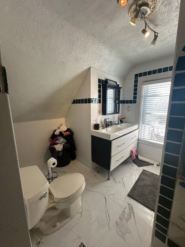 238 Ann St, West Chicago, IL 60185 - bathroom with toilet, a textured ceiling, vanity, marble finish floor, and lofted ceiling