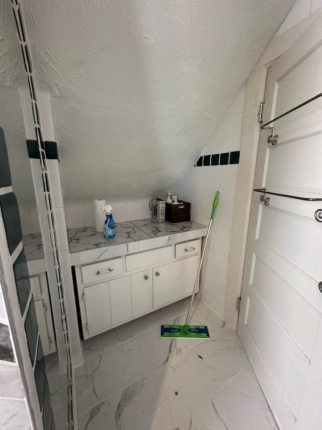 238 Ann St, West Chicago, IL 60185 - bathroom featuring marble finish floor, vaulted ceiling, and a textured ceiling