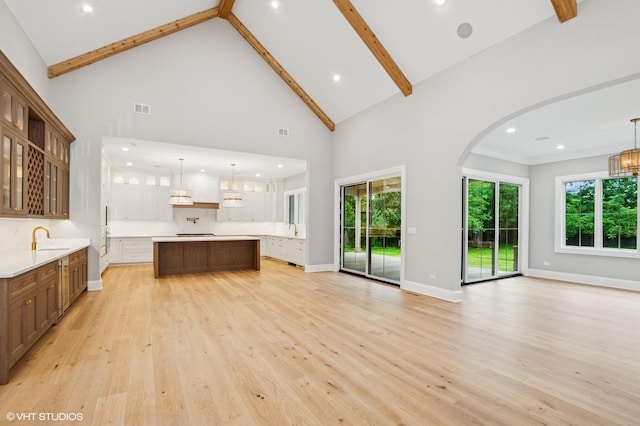 10940 German Church Rd, La Grange, IL 60525 - unfurnished living room featuring light wood-type flooring, high vaulted ceiling, beamed ceiling, arched walkways, and recessed lighting