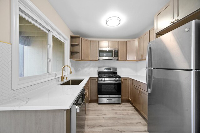 kitchen featuring tasteful backsplash, open shelves, stainless steel appliances, light wood finished floors, and a sink