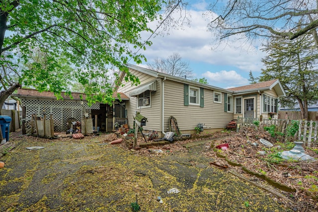 back of property featuring driveway and a fenced backyard