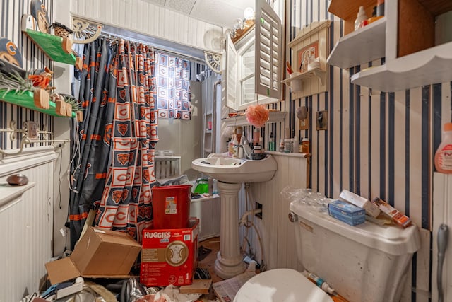 basement with a wall mounted air conditioner and a drop ceiling