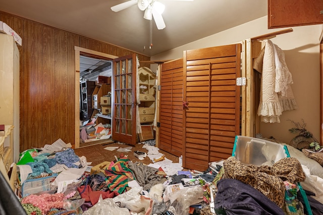 misc room with a ceiling fan and wood walls