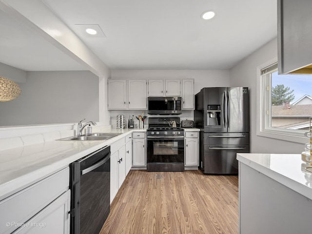 133 Abbeywood Cir, Streamwood, IL 60107 - kitchen featuring light wood-style floors, appliances with stainless steel finishes, a sink, and white cabinetry