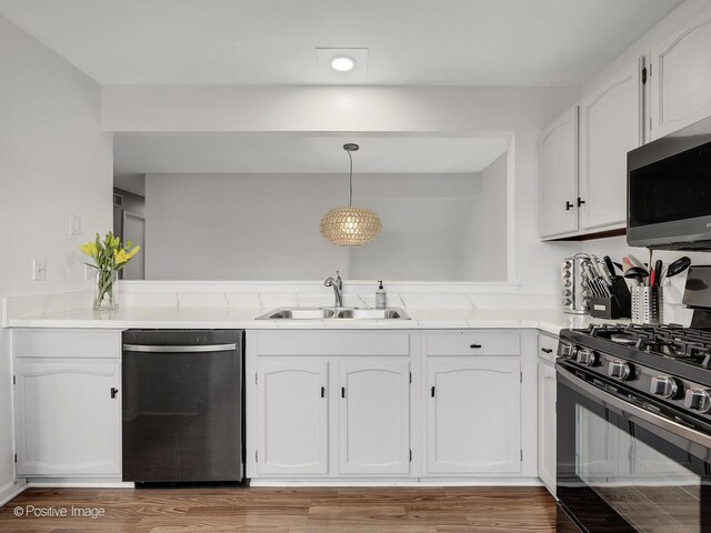 133 Abbeywood Cir, Streamwood, IL 60107 - kitchen with a sink, light countertops, light wood-type flooring, appliances with stainless steel finishes, and white cabinetry