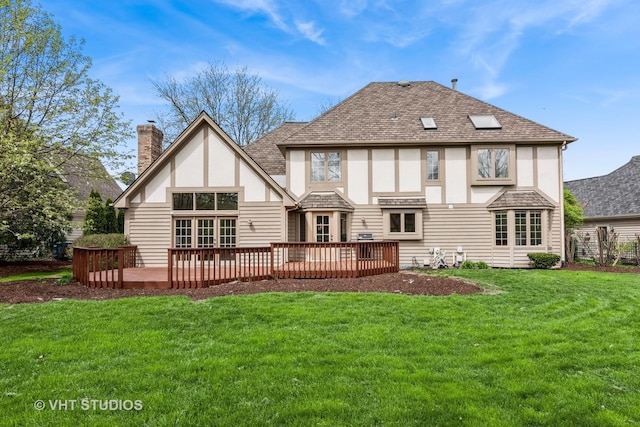 back of property featuring a wooden deck, stucco siding, a yard, and a chimney