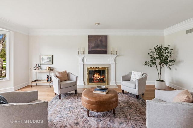 living area with crown molding, a high end fireplace, baseboards, and wood finished floors