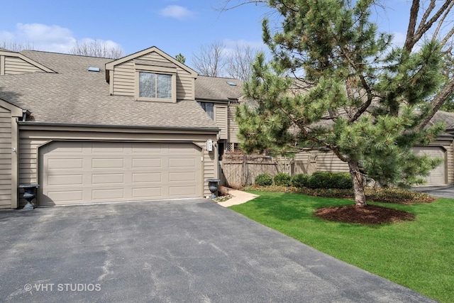 view of front facade featuring roof with shingles, driveway, and a garage