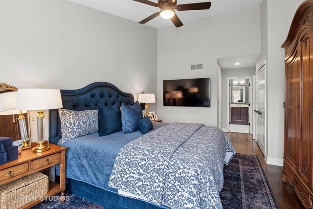 bedroom with wood finished floors, vaulted ceiling, baseboards, a ceiling fan, and ensuite bathroom