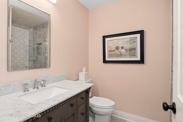 full bath featuring toilet, a tile shower, and vanity