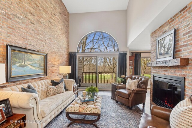living room featuring a towering ceiling and a brick fireplace