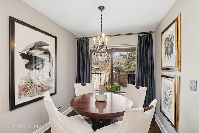 dining room featuring a chandelier, wood finished floors, and baseboards