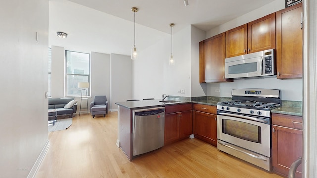 8 W Monroe St Unit 1507, Chicago, IL 60603 - kitchen with stainless steel appliances, light wood-style floors, dark countertops, and brown cabinetry