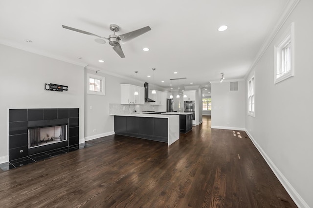 1615 W Superior St, Chicago, IL 60622 - kitchen with light countertops, ornamental molding, recessed lighting, wall chimney range hood, and a peninsula