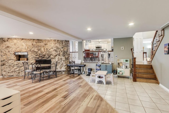 living area featuring recessed lighting, stairs, light wood finished floors, and baseboards