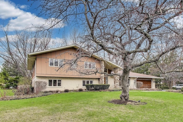 view of front facade featuring brick siding, a front lawn, and an attached garage