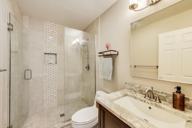 full bathroom featuring toilet, vanity, and a shower stall