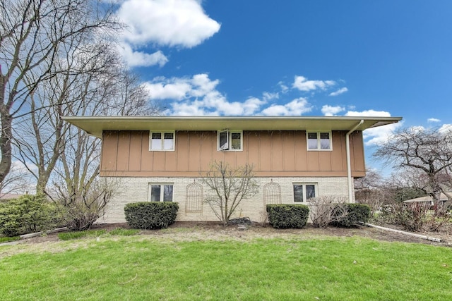 view of property exterior featuring brick siding and a lawn