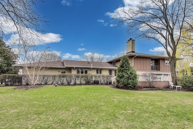 rear view of property with a yard and a chimney