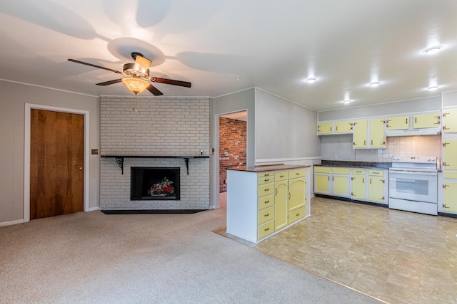 kitchen featuring white electric range oven, ceiling fan, green cabinets, under cabinet range hood, and a brick fireplace