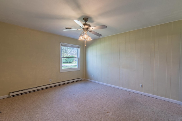 carpeted spare room featuring baseboard heating, baseboards, and a ceiling fan