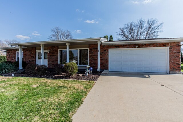ranch-style house with brick siding, an attached garage, a front lawn, and concrete driveway